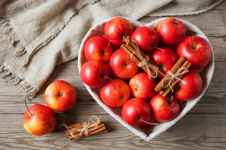 apples in heart dish with cinnamon sticks