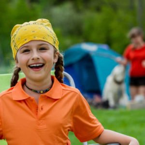 girl camping with family and dog