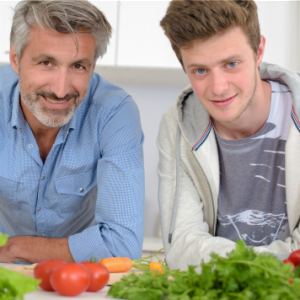 teenage boy and dad preparing vegetarian teenage meal plan with tomatoes, carrots, and other veggies - SuperKidsNutrition