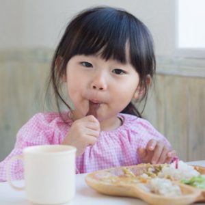 Asian Girl eating vegetables