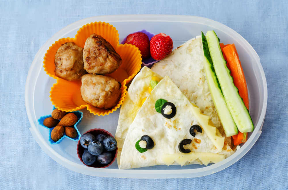 school lunch box for kids with food in the form of funny faces. the toning. selective focus