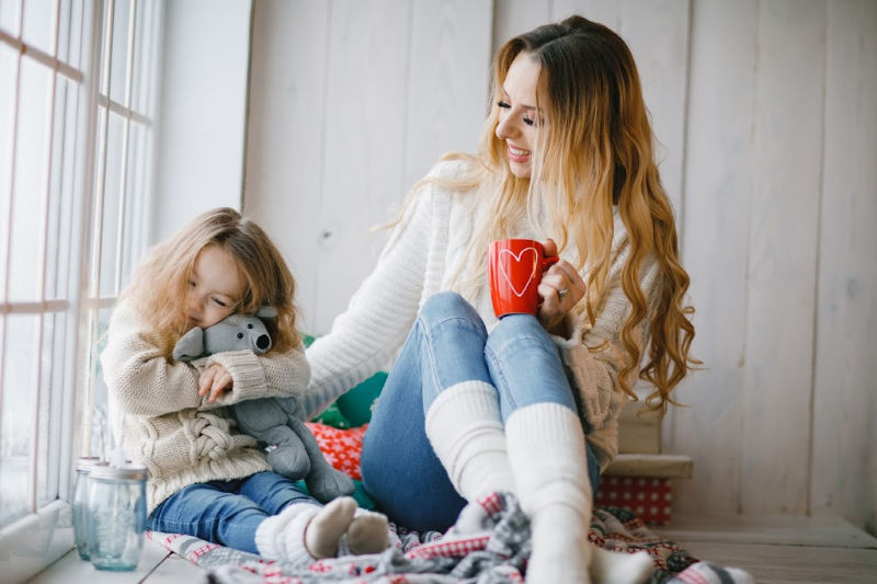 mom and daughter dressed in cozy clothes for a relaxing holiday