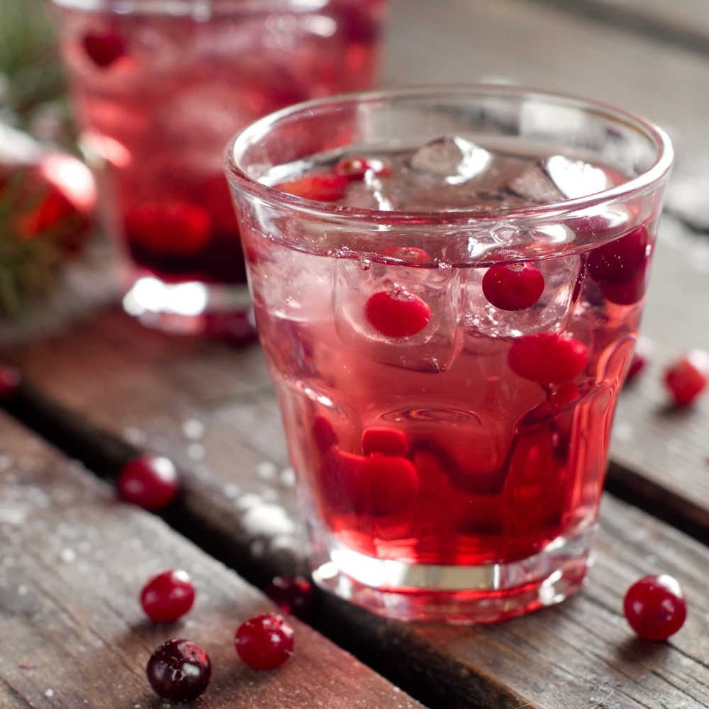 holiday drink water infused with cranberries on a wood table