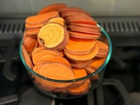 sweet potato rounds in bowl on stove top for holiday party dish