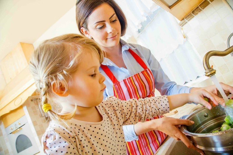 mom and daughter washing brussels sprouts for healthy holiday appetizer