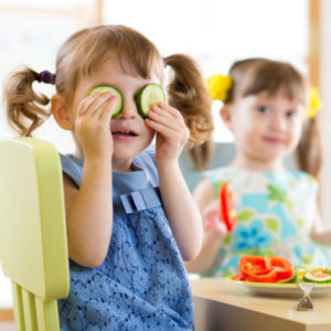 Cute kids eating healthy food in kindergarten or at home