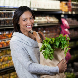 black woman shopping at store buying whole foods and looking in the bulk section