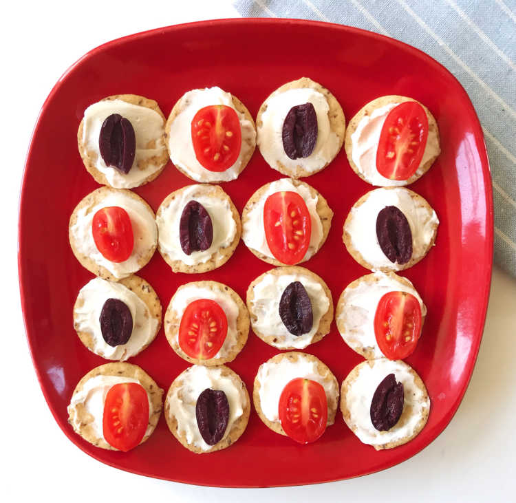 Crackers with cheese, olives, and tomatoes