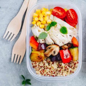 Meal prep lunch box containers with quinoa, grilled and fresh vegetables and chicken