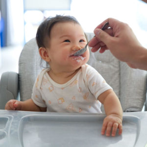 baby feeding in high chair with parent feeding spoon - SuperKids Nutrition