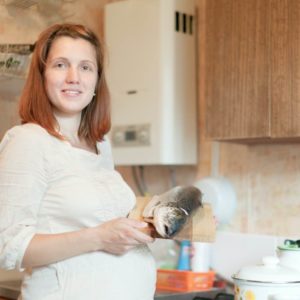 pregnancy woman with fish in kitchen fish safe for pregnancy