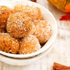 pumpkin chocolate chip energy balls in a white bowl with coconut topping