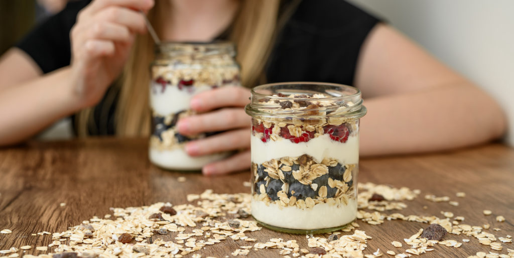Girl making real fruit and yogurt parfait